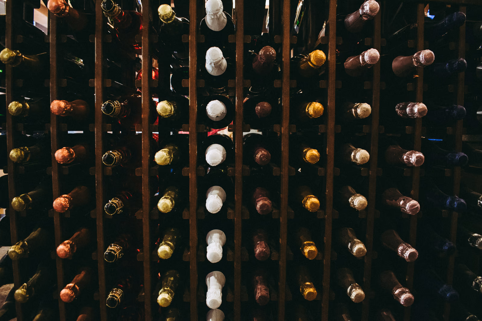 Wine bottles stored in a wooden cellar rack